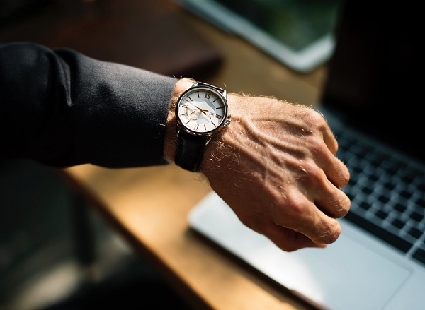 Werkstudent Informationen - Mann schaut auf seine Uhr am Handgelenk Werkstudent Informationen - Mann schaut auf seine Uhr am Handgelenk